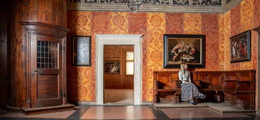 Ragazza seduta vicino alla scala nel Palazzo della Magnifica Comunità di Fiemme | © APT Fiemme e Cembra - foto di Mattia Rizzi