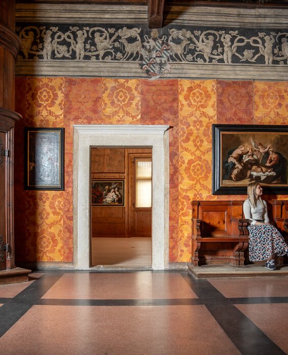 Ragazza seduta vicino alla scala nel Palazzo della Magnifica Comunità di Fiemme | © APT Fiemme e Cembra - foto di Mattia Rizzi
