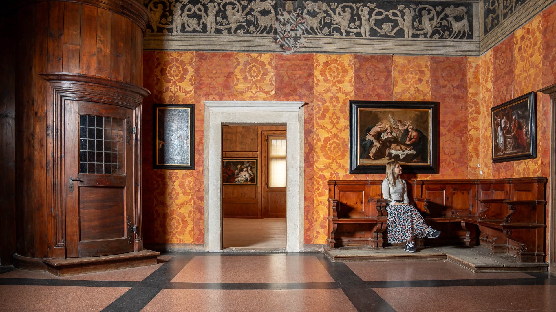 Ragazza seduta vicino alla scala nel Palazzo della Magnifica Comunità di Fiemme | © APT Fiemme e Cembra - foto di Mattia Rizzi
