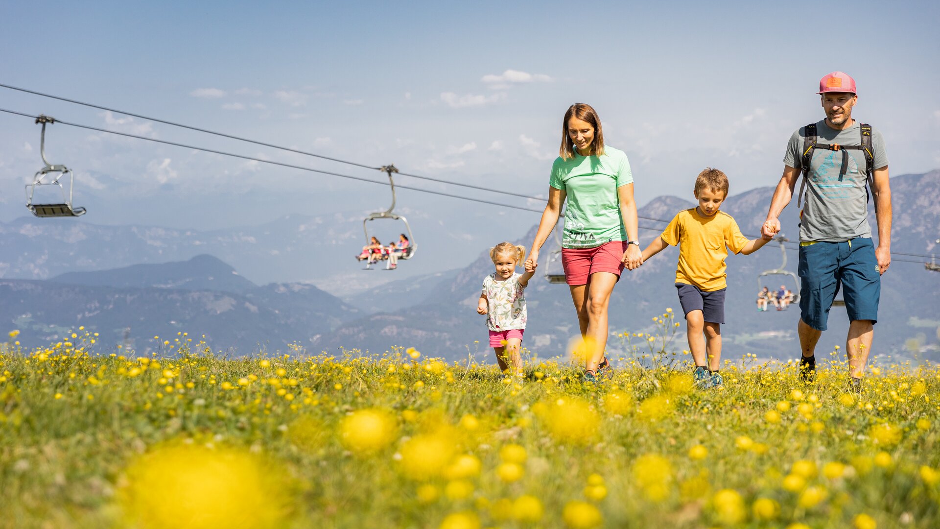 Genitori con bambini passeggiano all'Alpe Cermis mano nella mano | © APT Fiemme e Cembra - Gaia Panozzo