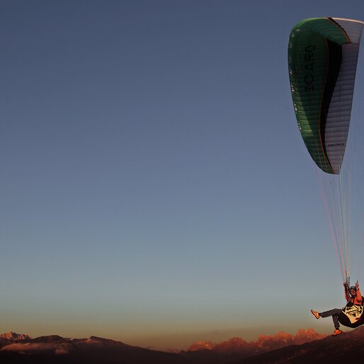 Parapendista all'imbrunire con Pale di San Martino sullo sfondo | © APT Fiemme e Cembra