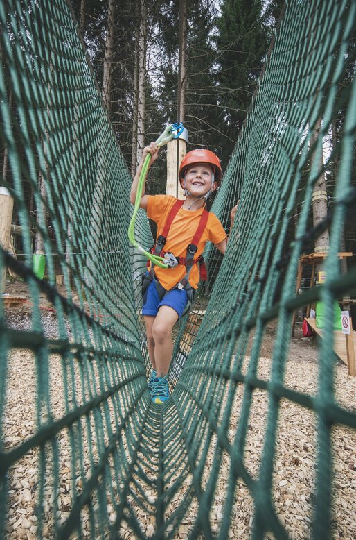 Bambino percorre un tratto di percorso in una rete | © APT Fiemme e Cembra - Federico Modica