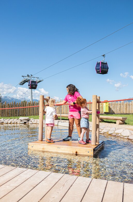 Tre bambine sulla zattera del laghetto al parco Giro d'Ali | © APT Fiemme e Cembra - Gaia Panozzo