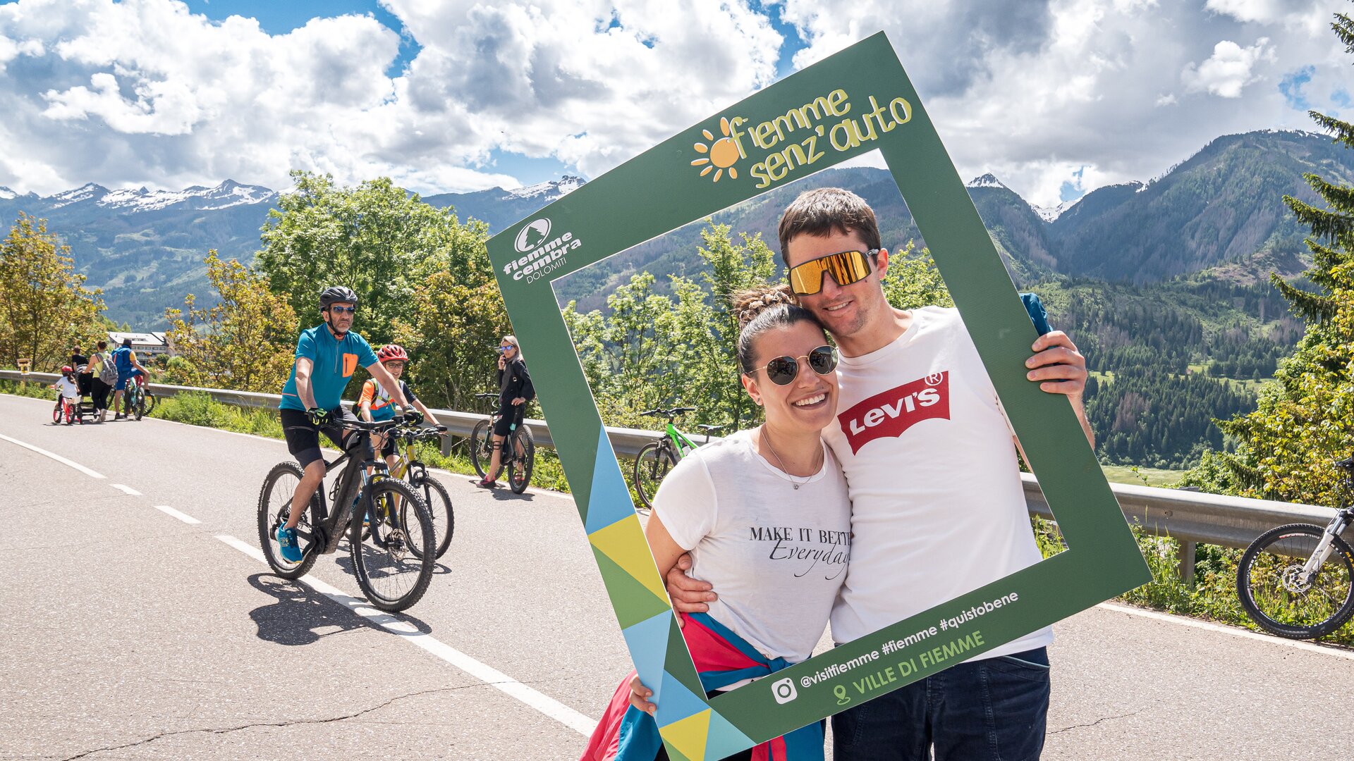 Pedoni si fanno scattare una foto sulla strada statale con la cornice di Fiemme Senz'Auto | © APT Fiemme e Cembra - foto di Mattia Rizzi