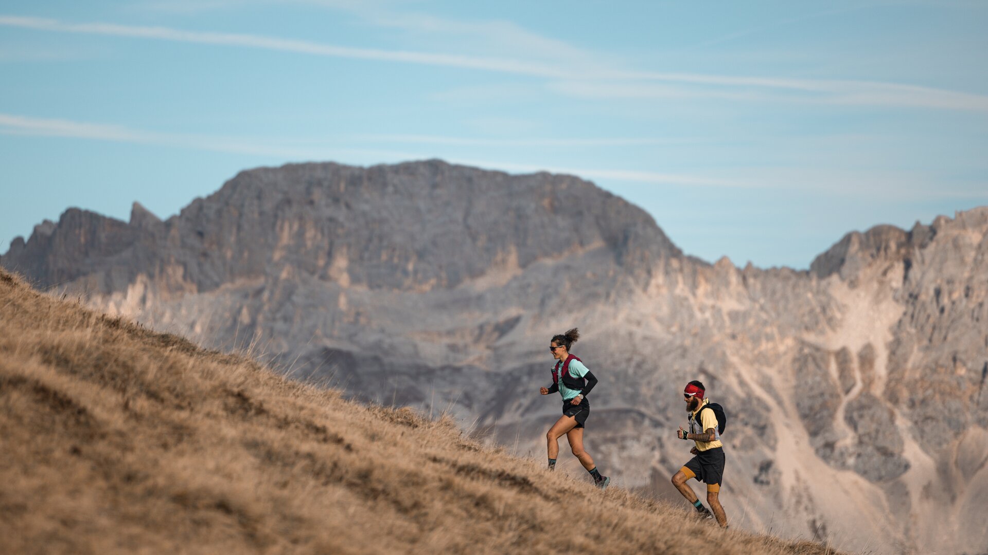 Due trail runners corrono con il Latemar sullo sfondo | © APT Fiemme e Cembra - foto di Gaia Panozzo
