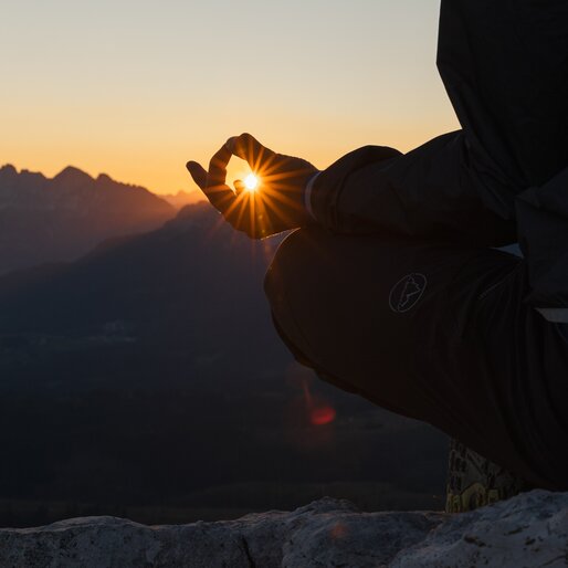 Dettaglio di persona in meditazione verso il sole appena sorto | © APT Fiemme e Cembra - Gaia Panozzo