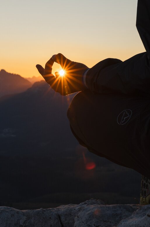 Dettaglio di persona in meditazione verso il sole appena sorto | © APT Fiemme e Cembra - Gaia Panozzo